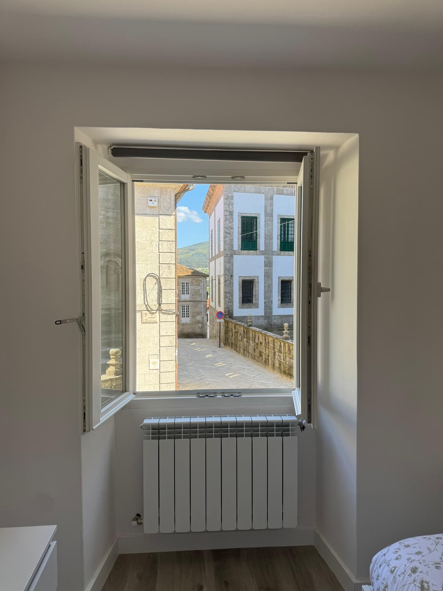 Dormitorio con ventana abierta y vistas al casco histórico de Tui